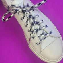 black and white checkered shoe laces on white canvas low top shoe