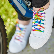 tie dye shoelaces on white chucks on a bike pedal